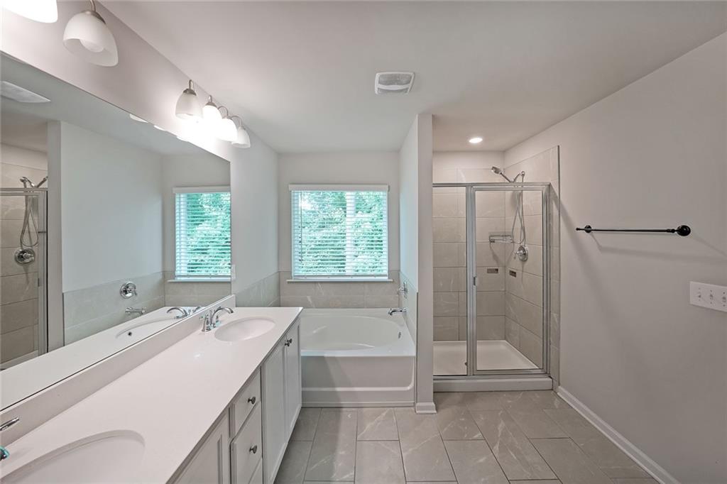 4450 Richmond Court Stone Mountain, GA 30083 - Photo 18 of 31 a spacious bathroom with a shower sink and mirror