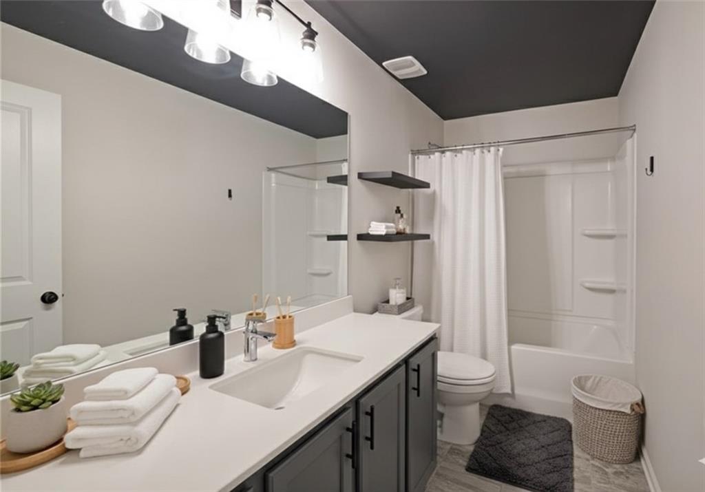 4450 Richmond Court Stone Mountain, GA 30083 - Photo 23 of 31 a bathroom with a granite countertop sink a toilet and shower