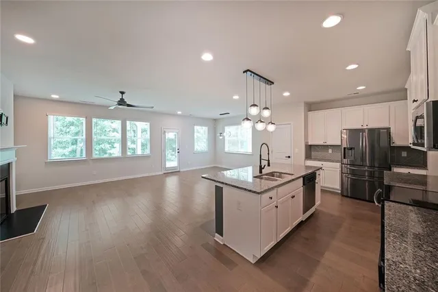 a kitchen with stainless steel appliances granite countertop a sink stove and refrigerator