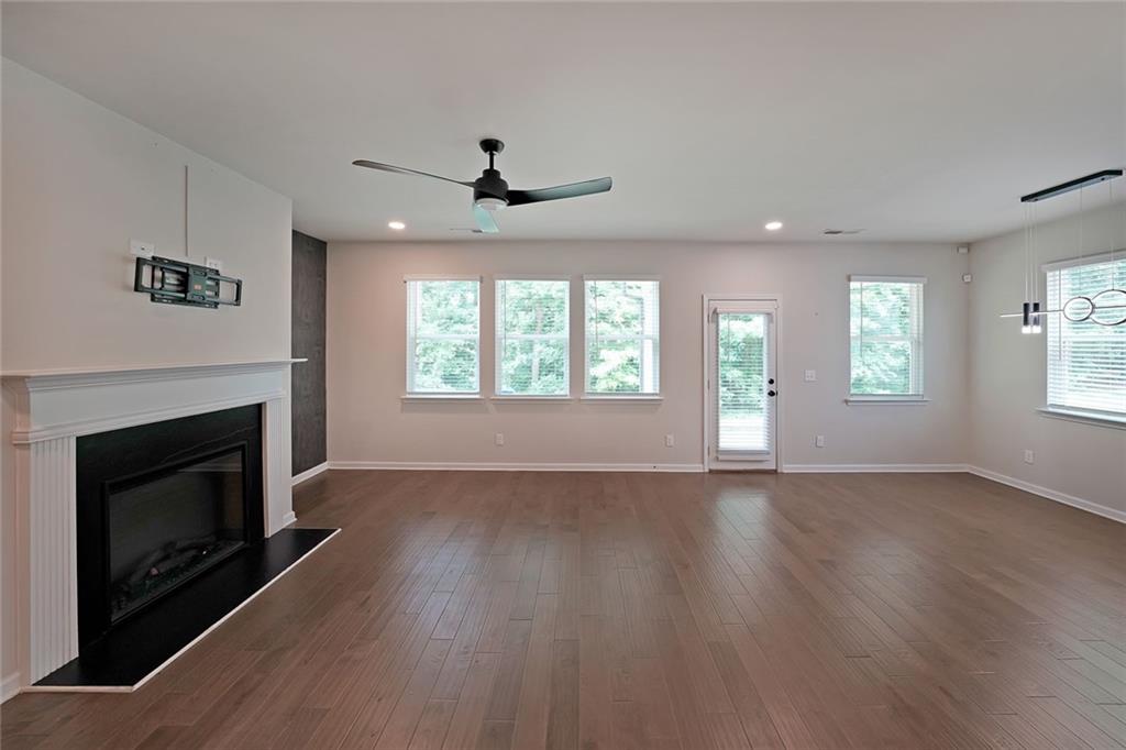 4450 Richmond Court Stone Mountain, GA 30083 - Photo 5 of 31 a view of an empty room with wooden floor fireplace and a window