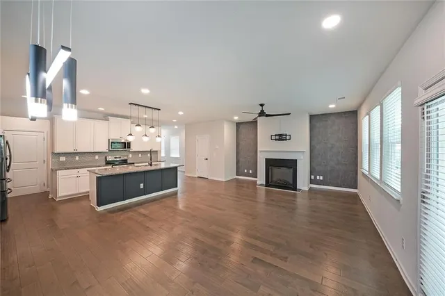 a large white kitchen with a stove top oven and refrigerator