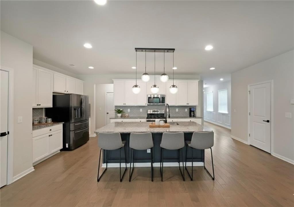 4450 Richmond Court Stone Mountain, GA 30083 - Photo 8 of 31 a view of a dining room with furniture a kitchen and chandelier