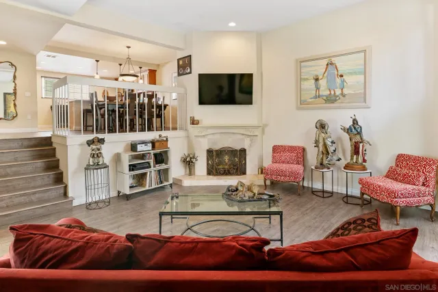 a living room with furniture a flat screen tv and kitchen view