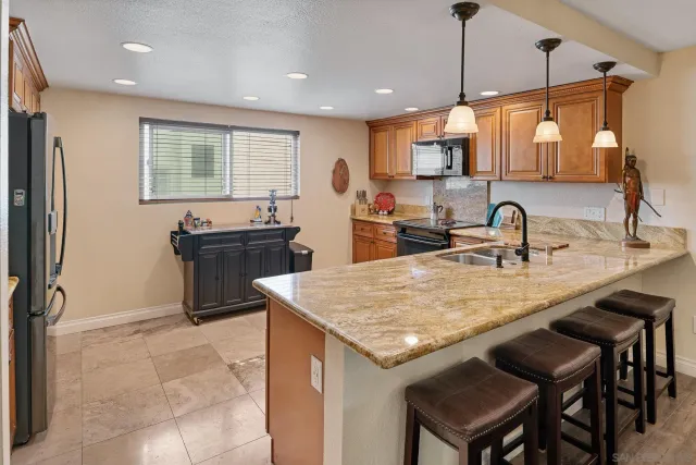 a kitchen with stainless steel appliances granite countertop a stove sink microwave and window