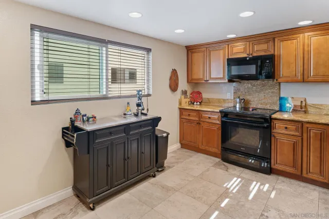a kitchen with stainless steel appliances granite countertop a sink a stove and a refrigerator