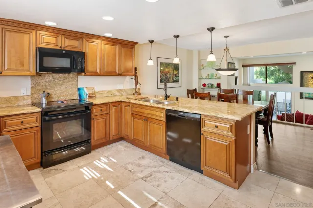 a kitchen with a sink stainless steel appliances and chandelier