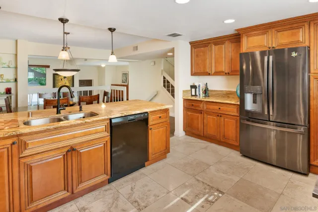 a kitchen with stainless steel appliances granite countertop a refrigerator stove and sink