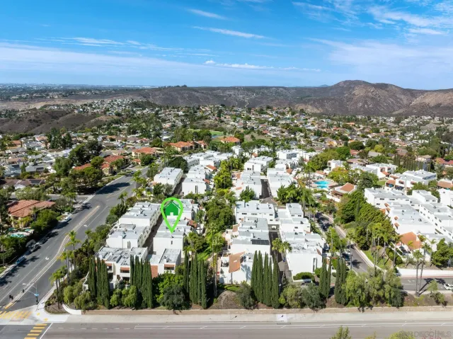 an aerial view of residential houses with outdoor space and trees