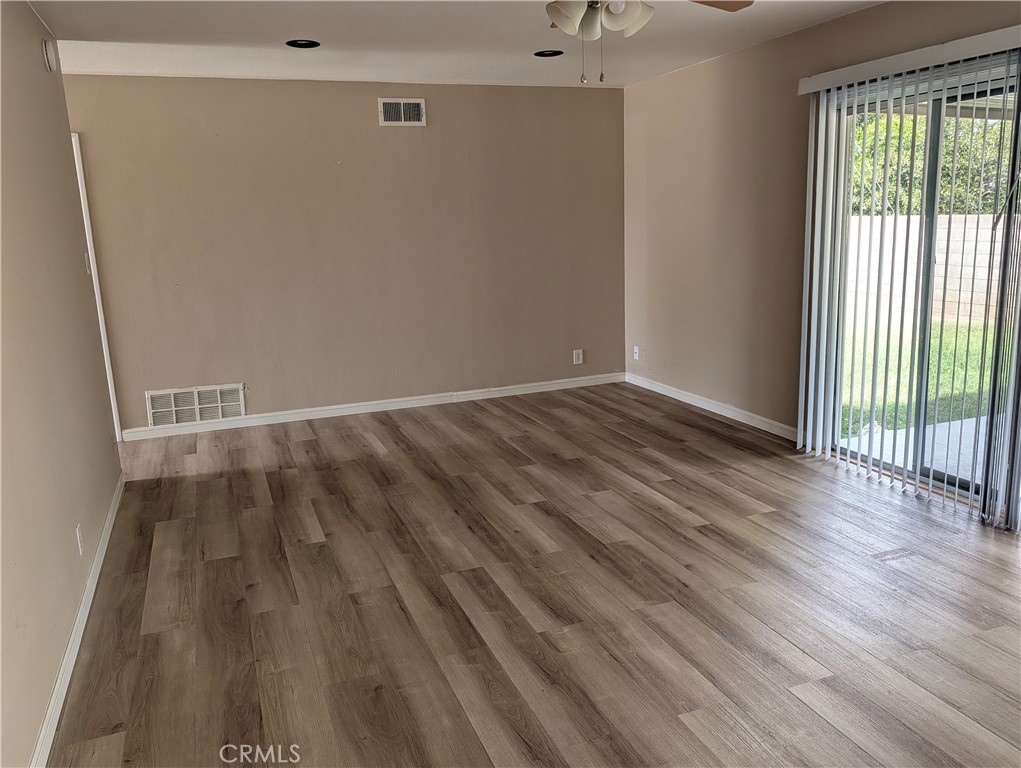 8641 Garfield Street Riverside, CA 92504 - Photo 8 of 19 a view of an empty room with wooden floor and a window