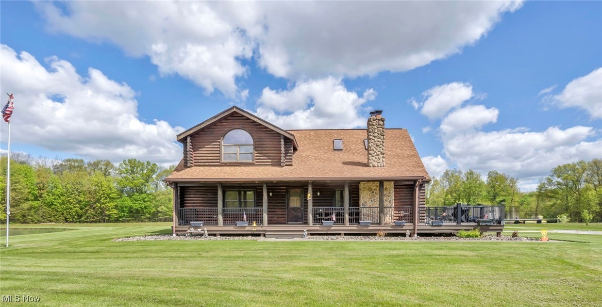 15180 Stoltz Road Diamond, OH 44412 - Photo 2 of 48 Front view of house with log siding, a lawn, and a chimney