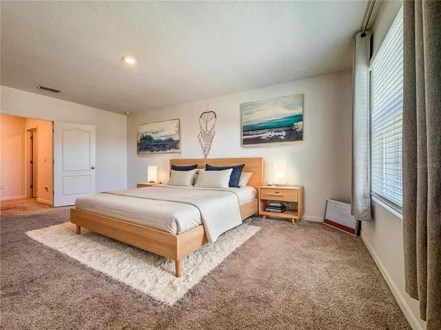 a bedroom with a bed and a painting on the wall