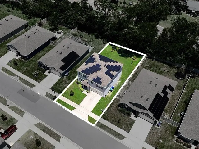 an aerial view of a house with a big yard