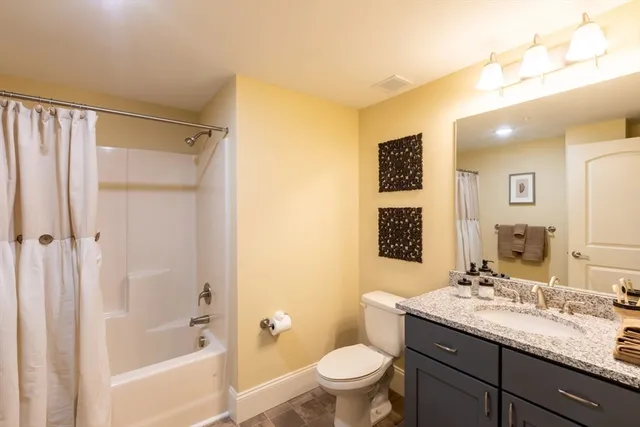 a bathroom with a granite countertop sink toilet and shower