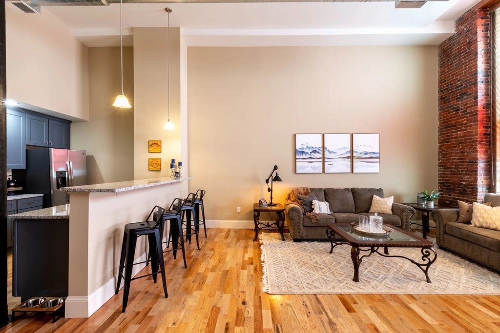 300 Canal Street, Unit 1507 Lawrence, MA 01840 - Photo 3 of 20 a living room with furniture and a wooden floor