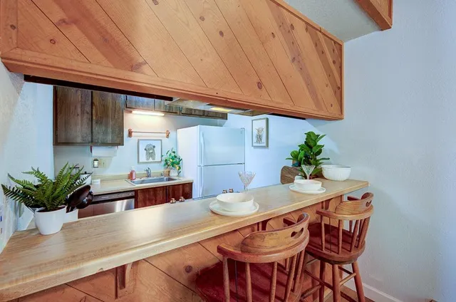 a dining room with furniture and potted plants