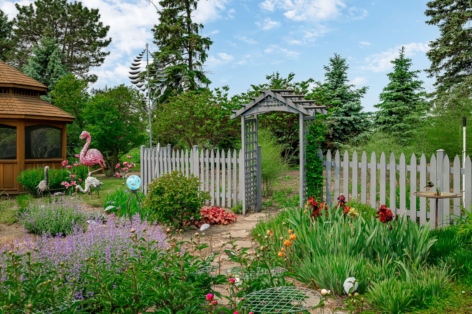 29295 North Callahan Road Wauconda, IL 60084 - Photo 23 of 45 a view of a garden with lots of flower plants and wooden fence