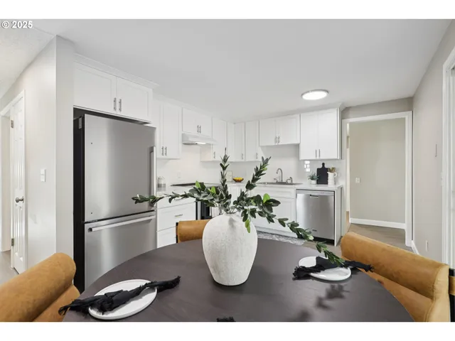a kitchen with a refrigerator and a white cabinets