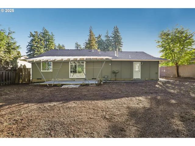 a view of a house with a yard and a tree