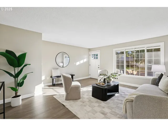 a living room with furniture a window and a potted plants