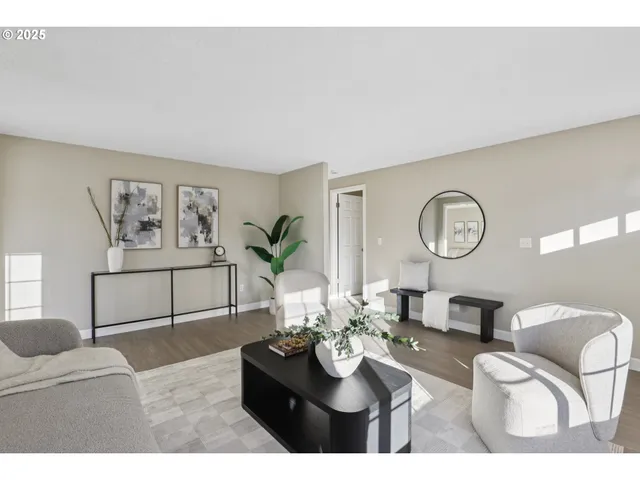 a living room with furniture a rug and wall paintings