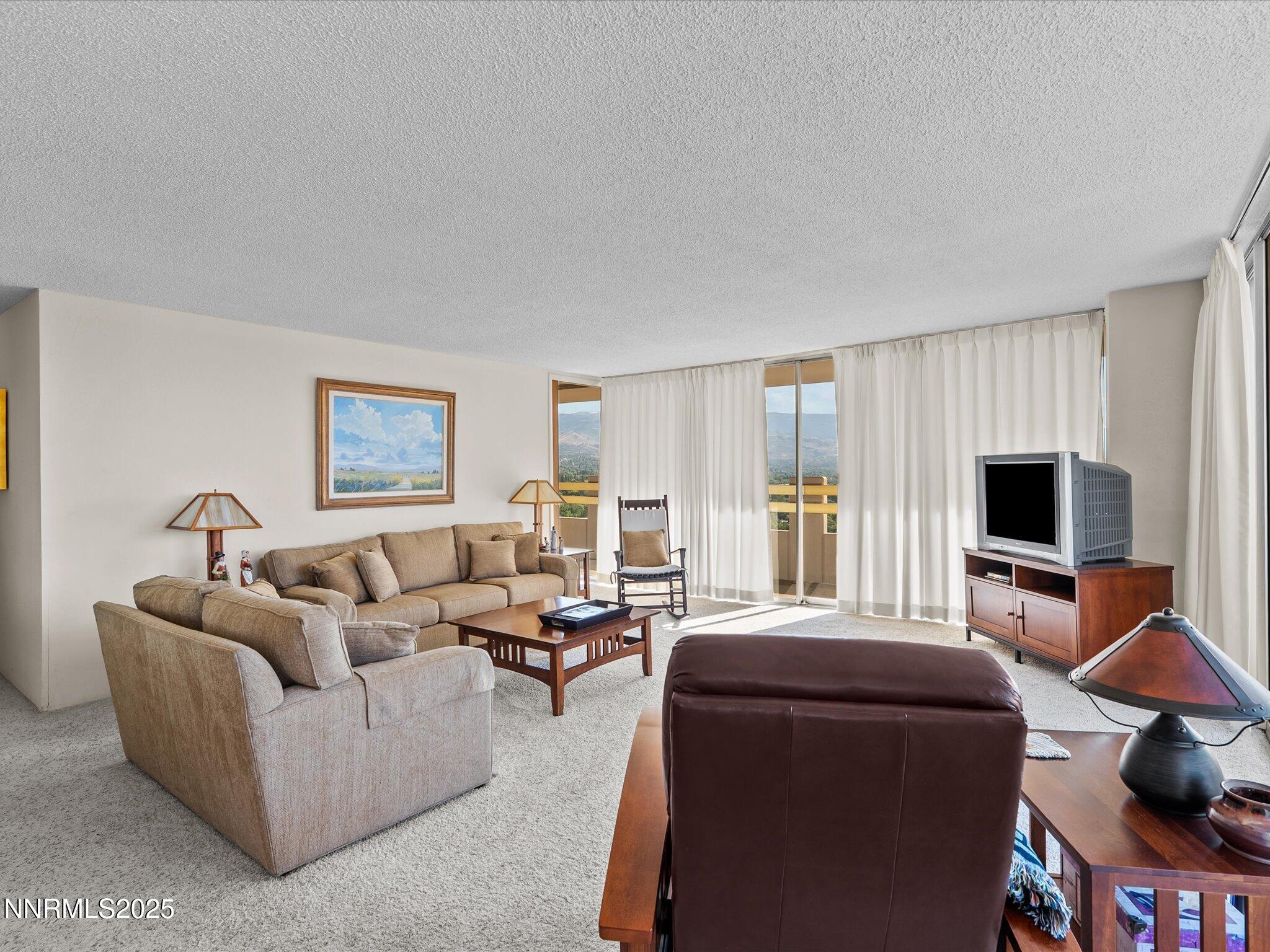 100 North Arlington Avenue, Unit 20J Reno, NV 89501 - Photo 7 of 17 a living room with furniture and a flat screen tv