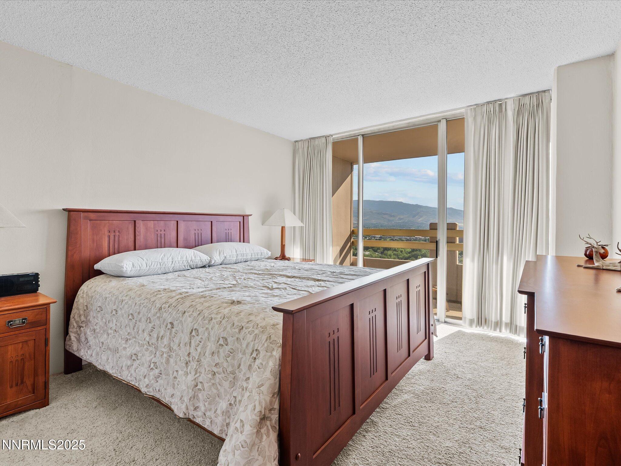 100 North Arlington Avenue, Unit 20J Reno, NV 89501 - Photo 9 of 17 a spacious bedroom with a bed and a large window