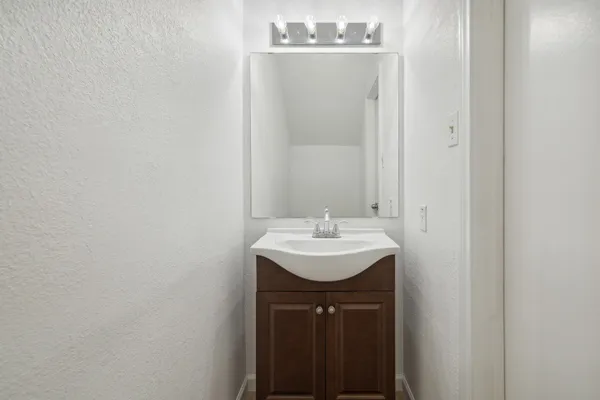 a bathroom with a sink a mirror and vanity