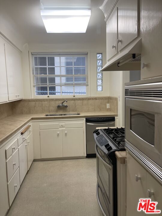 1292 Devon Avenue, Unit 1294 Los Angeles, CA 90024 - Photo 6 of 12 a kitchen with granite countertop a stove sink and cabinets