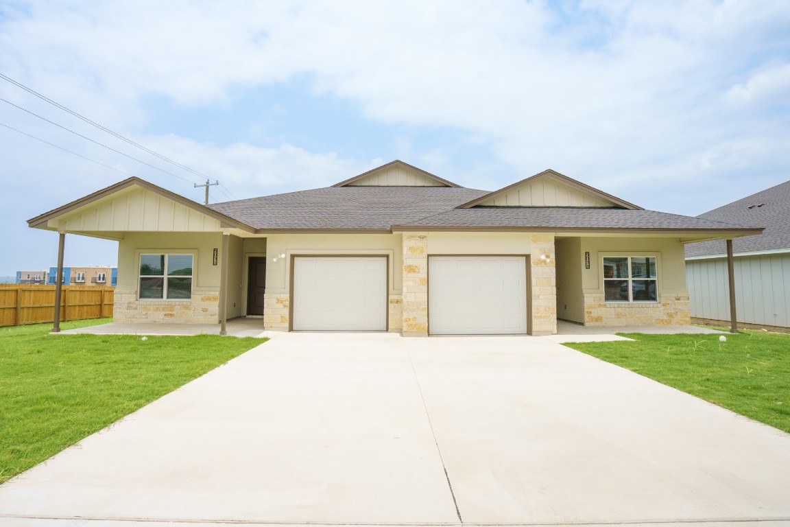 a front view of a house with a garden and yard