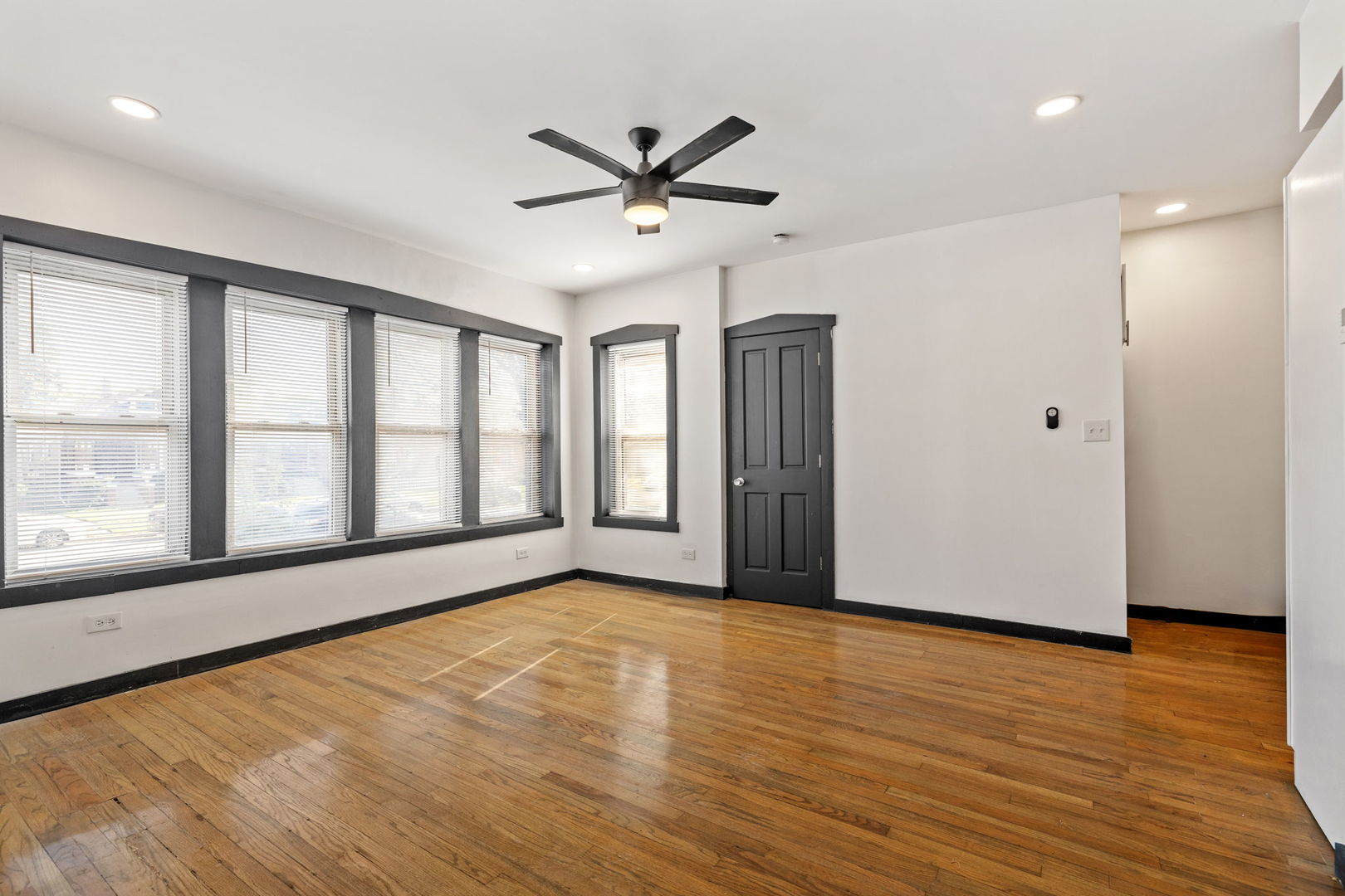 7202 South Indiana Avenue, Unit 1F Chicago, IL 60619 - Photo 3 of 7 a view of an empty room with a window and wooden floor