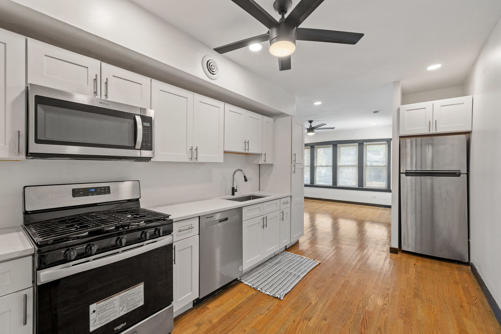 7202 South Indiana Avenue, Unit 1F Chicago, IL 60619 - Photo 5 of 7 a kitchen with stainless steel appliances a stove microwave and sink