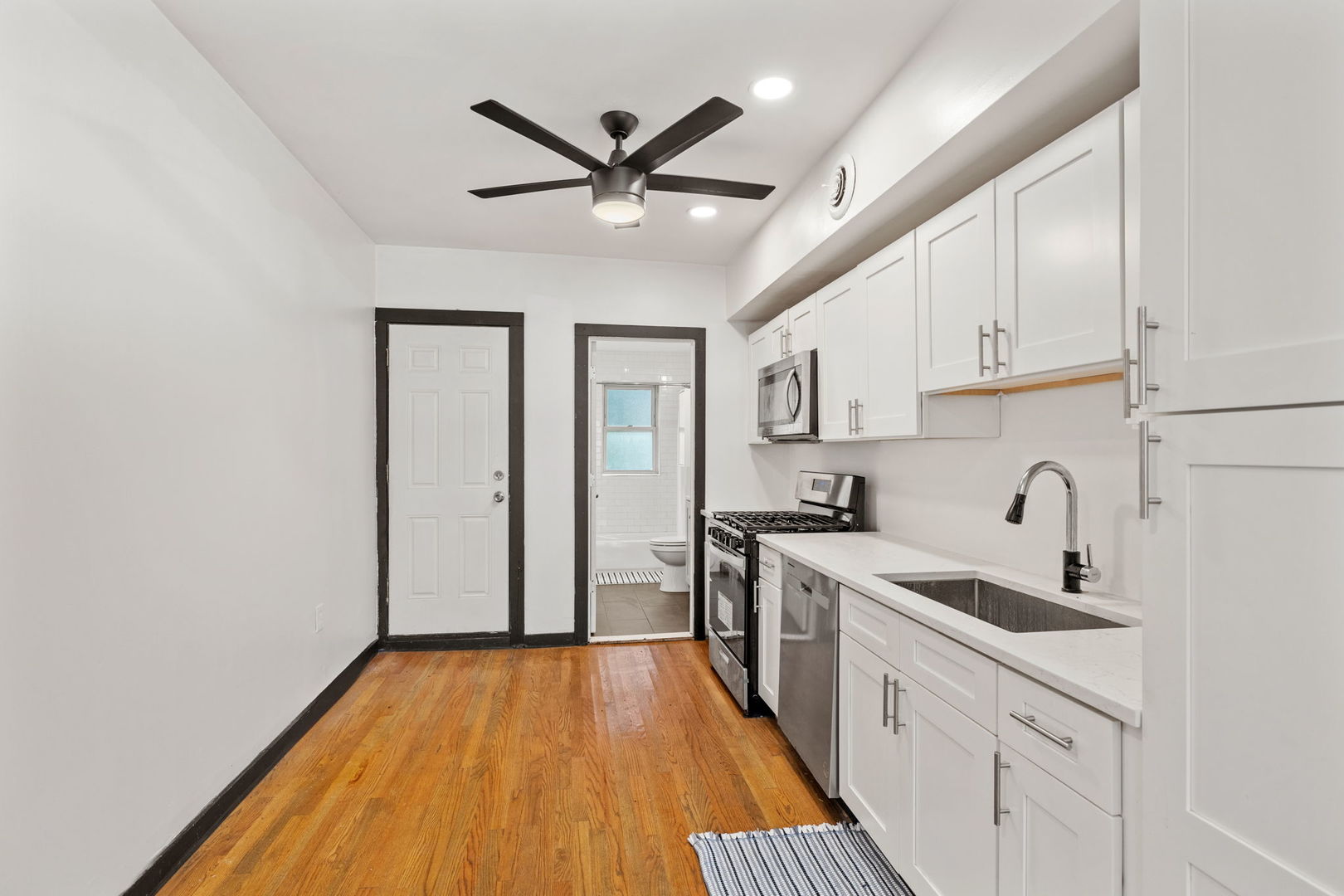7202 South Indiana Avenue, Unit 1F Chicago, IL 60619 - Photo 6 of 7 a kitchen with a sink a refrigerator and cabinets