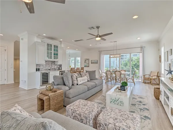 a living room with furniture wooden floor and a large window