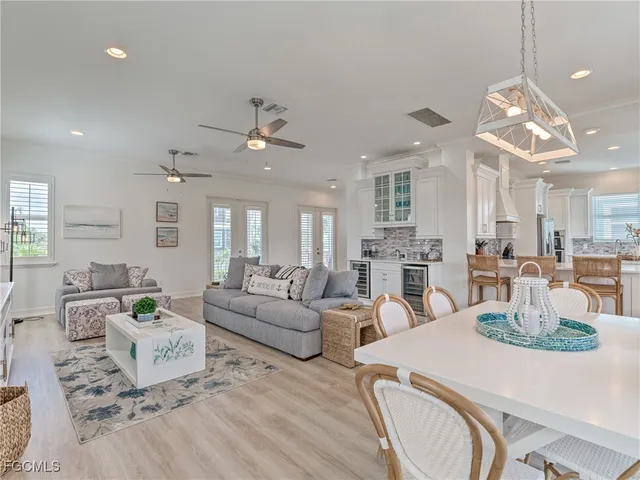 a living room with furniture kitchen view and a chandelier