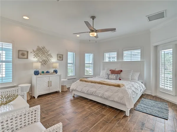 a bedroom with a large bed chandelier and a window