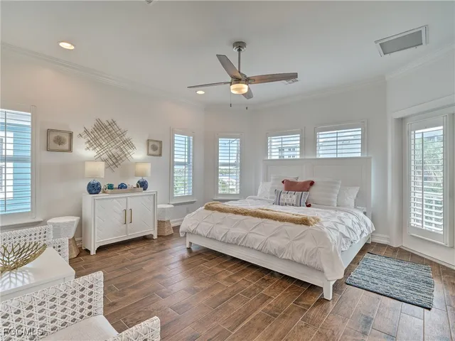 a bedroom with a large bed chandelier and a window