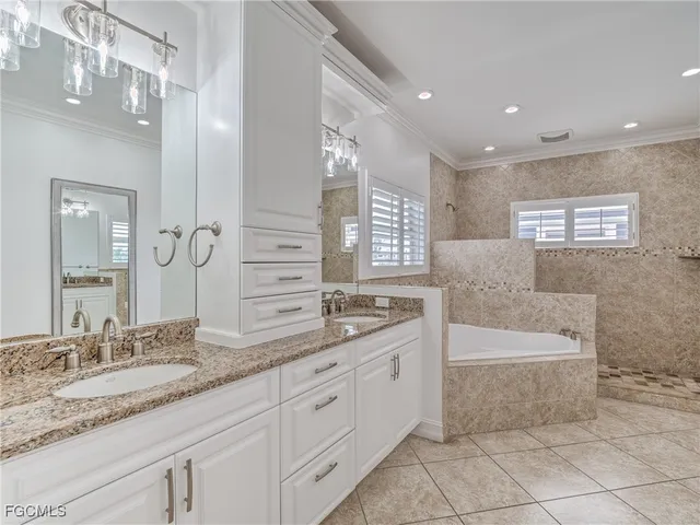 a bathroom with a granite countertop sink a large mirror and a bathtub