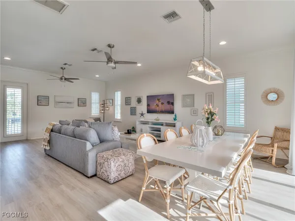 a living room with furniture kitchen view and a chandelier