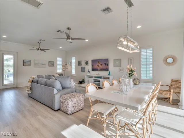 a living room with furniture kitchen view and a chandelier