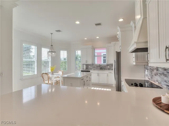 a large kitchen with kitchen island a large window a sink and a center island