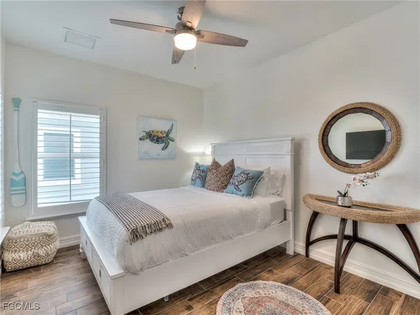 a bedroom with a bed a window and a chandelier