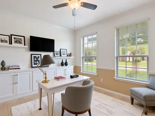 a work room with furniture a flat screen tv and a large window