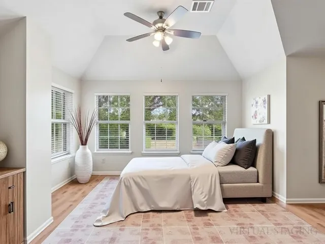 a spacious bedroom with a bed and a large window
