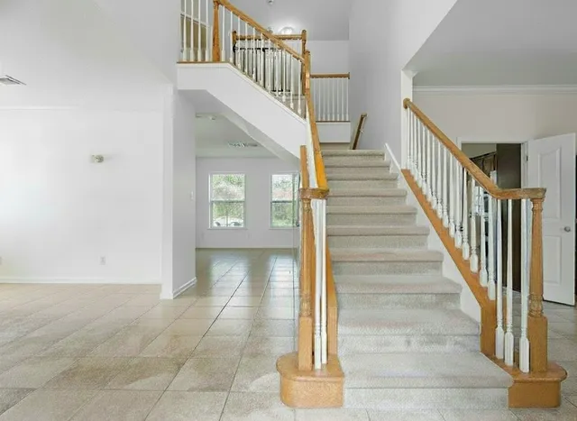 a view of staircase with white walls and railing