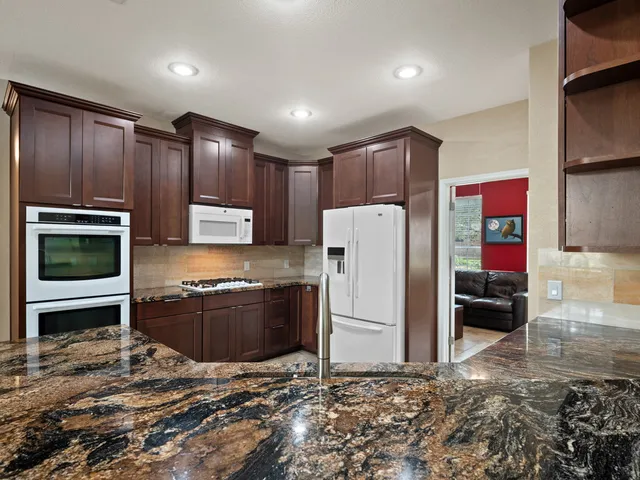 a kitchen with kitchen island granite countertop cabinets and refrigerator
