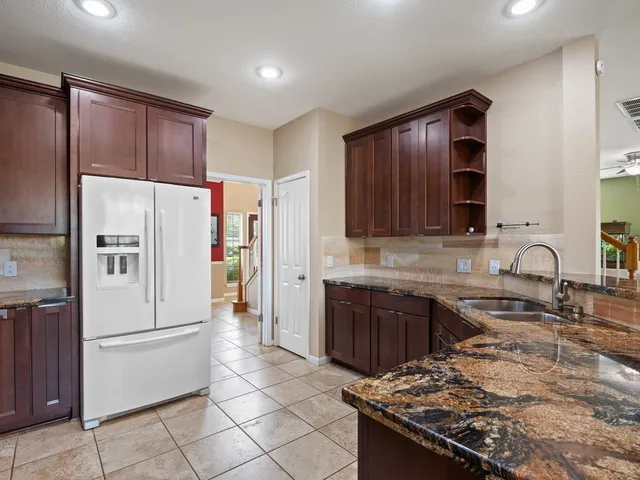 a kitchen with stainless steel appliances granite countertop a refrigerator stove and sink