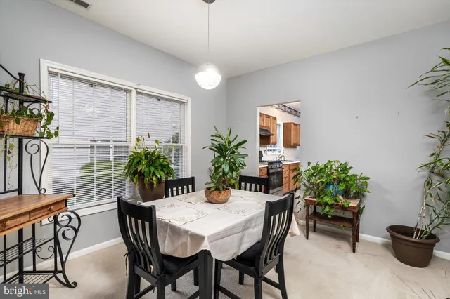 a view of a dining room with furniture and potted plants