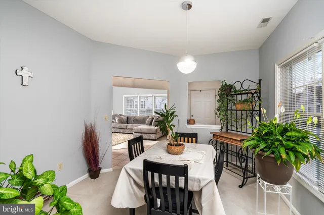 a dining room with furniture potted plants and wooden floor