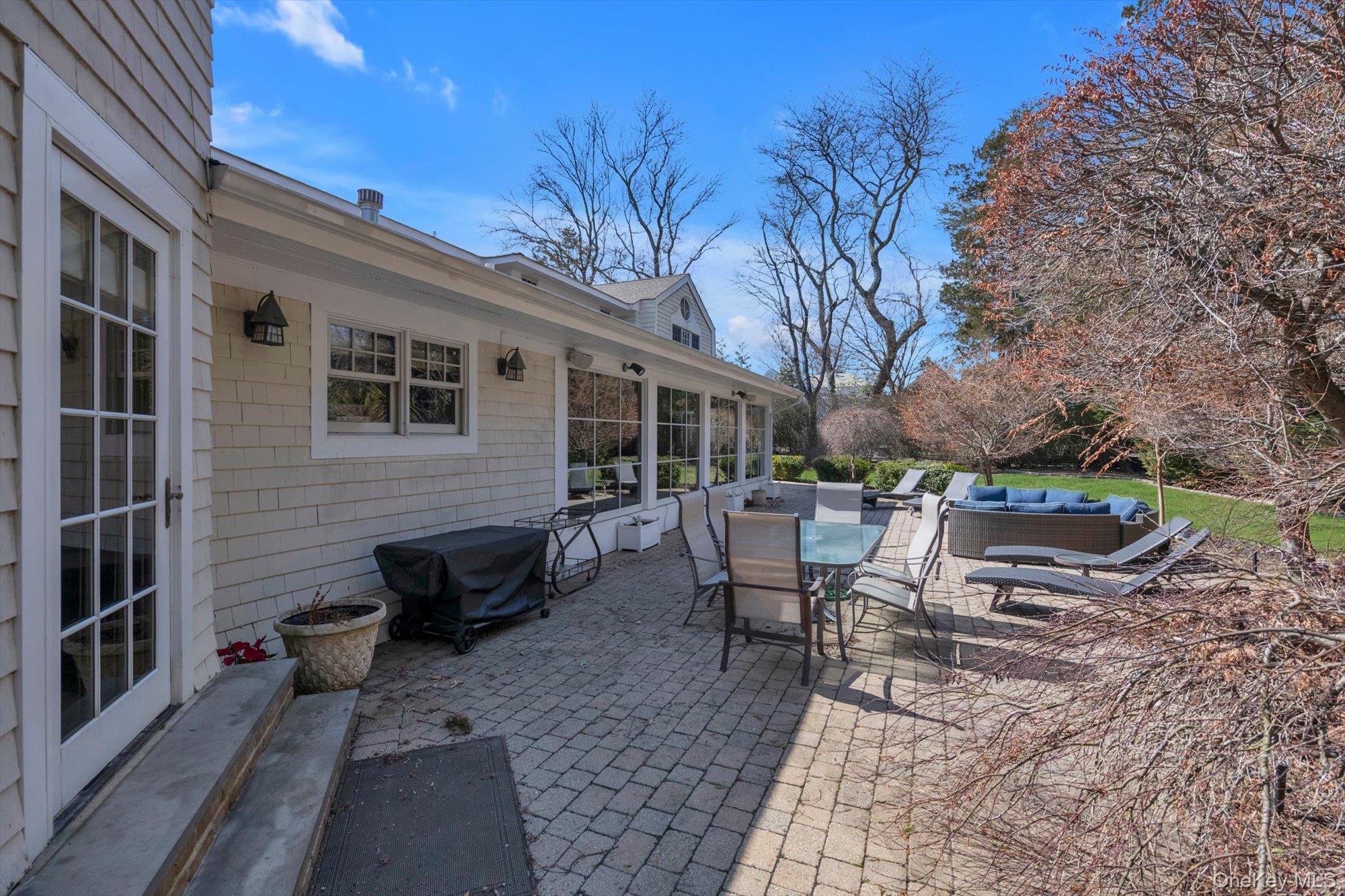 254 Adams Road Hewlett Harbor, NY 11557 - Photo 25 of 34 a view of a patio with couches table and chairs and potted plants