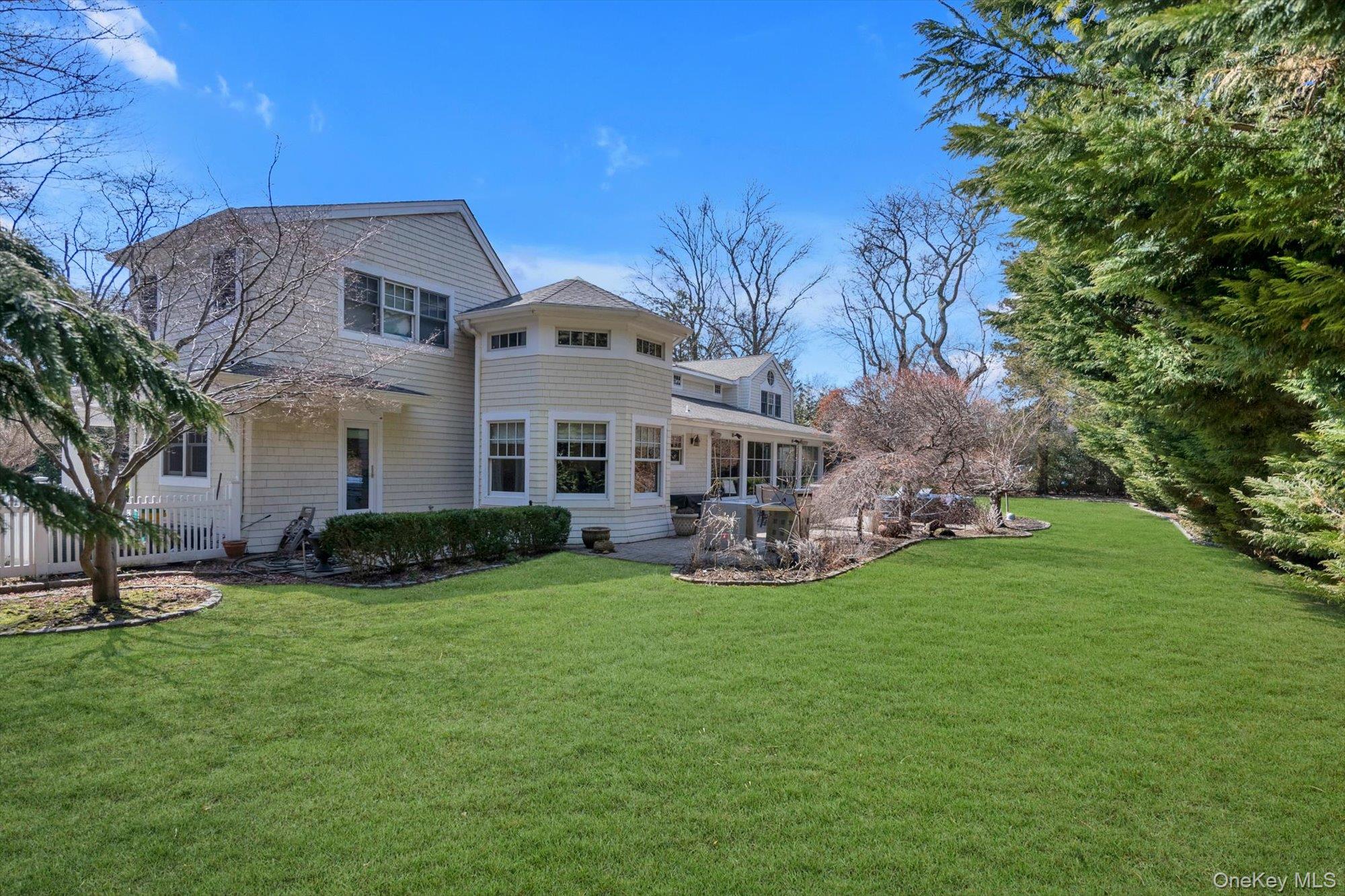 254 Adams Road Hewlett Harbor, NY 11557 - Photo 27 of 34 a front view of a house with garden and trees